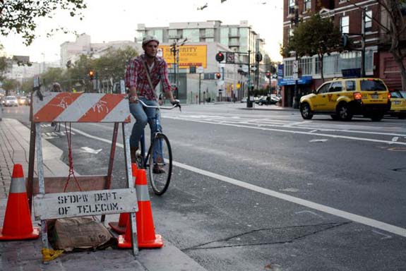 A bicyclist approaches a new bike counter on Market Street just west of Van Ness Avenue.