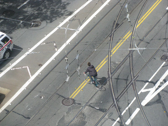 Northbound cyclists pedaling up 11th Street, which has a bike lane, often cross over the tracks to turn left.