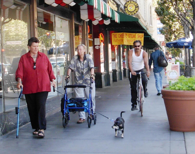 Cyclist on Sidewalk Passing Seniors