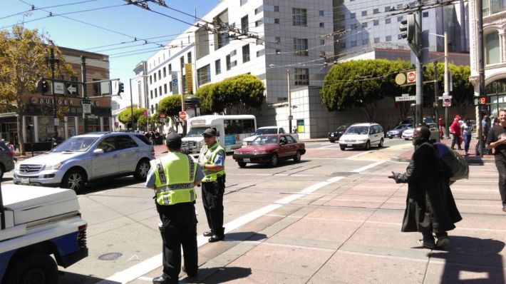 SFMTA parking control officers posted to instruct drivers not to turn on to Market at Eighth Streets. Photo: Aaron Bialick