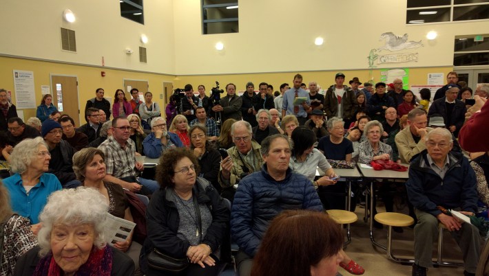 A mostly grumpy audience listens to Supervisor Tang and others talk about proposed improvements to the Taraval line. Photo: Streetsblog.