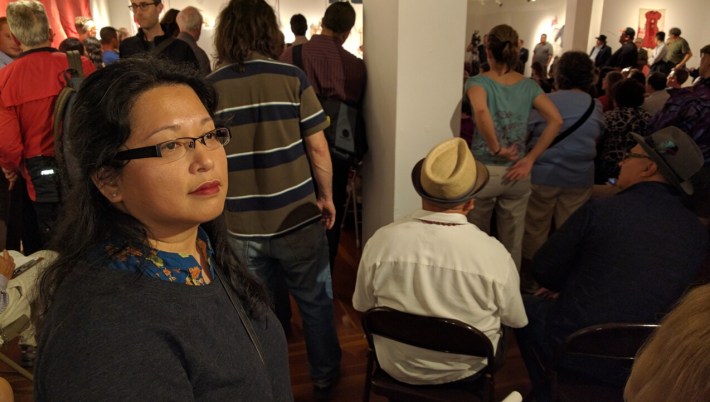 Christina Castro, who spoke in favor of the lanes for the San Francisco Transit Riders, catches her breath at the back of the sweltering room full of angry people Monday night. Photo: Streetsblog.