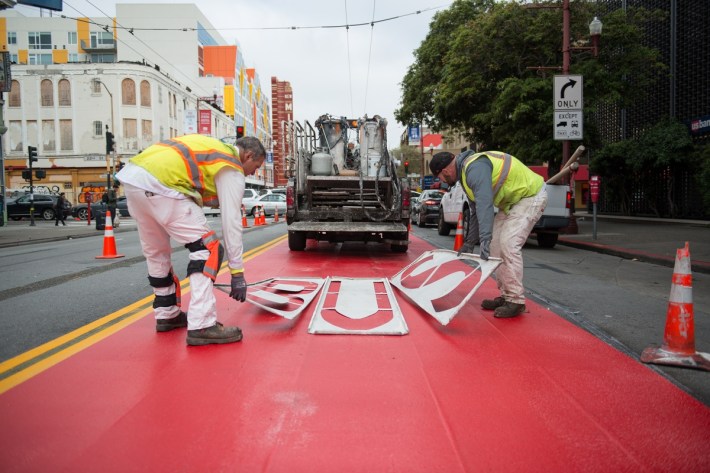 SFMTA painting the bus 'Red Carpet' lanes on Mission in the Mission a couple of years back. Photo: SFMTA.