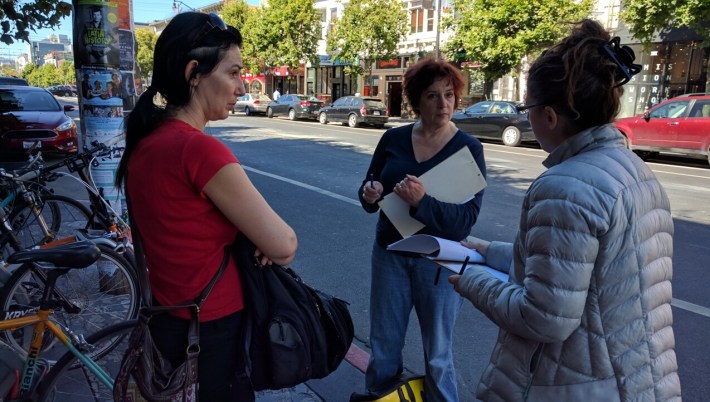 Volunteer advocates Natalie Angouleme and Maureen Persico take instructions from Catherine Orland before going out to count cars on bike lanes. Photo: Streetsblog.