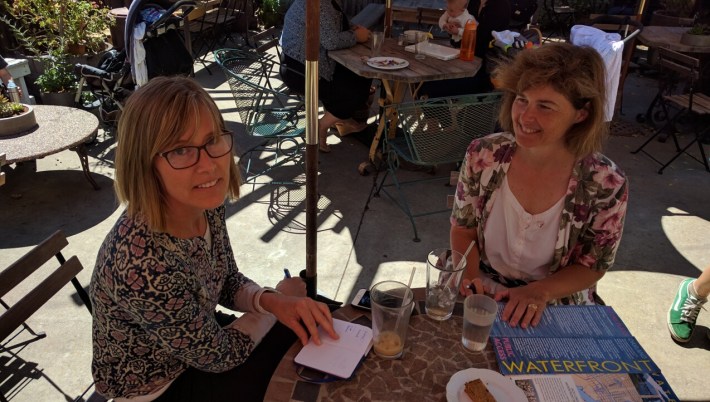 Cyndy Johnsen (glasses) and Lucy Gigli in the coffee shop "office" of BikeWalk Alameda. Photo: Streetsblog.