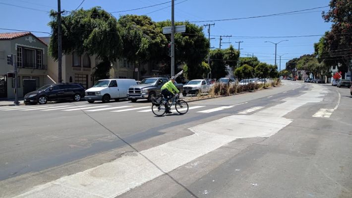A cyclist passing through the "black spot" where a man died yesterday in a traffic collision. Photo: Streetsblog/Rudick