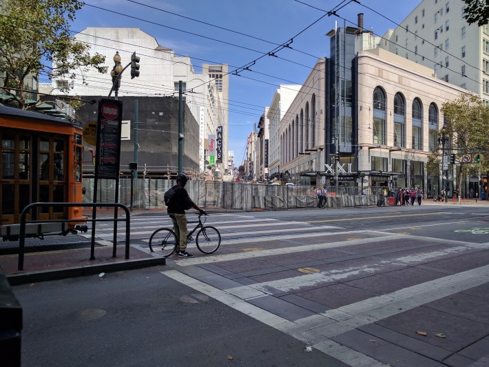 Fences and sound blankets around the huge hole for the Central Subway on Stockton Street at Market