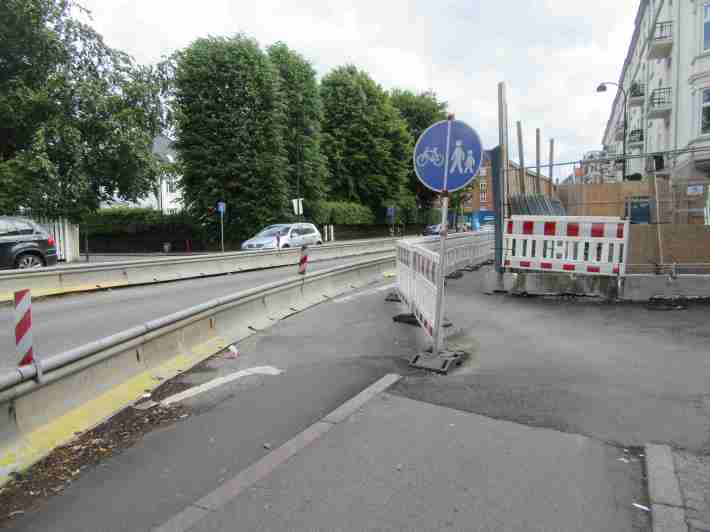 A temporary bike lane in Copenhagen. Notice the concrete rail to protected both cyclists and pedestrians, with a light weight divider to define cycling and walking space. Photo: Jason Henderson.