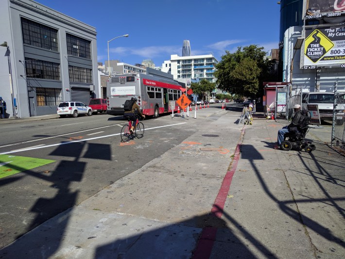 A cyclist enjoying NOT having to jostle for position with a bus at the installed boarding island on Folsom near 6th.