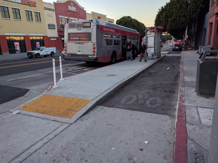 This bus boarding island at Potrero and 16th in San Francisco, requires bus riders to go down and up again to cross the bike lane at street level. Advocates want bikes to rise up instead. Photo: Streetsblog/Rudick
