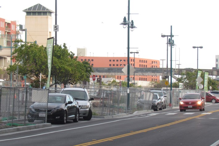 The parking lot behind the fence is not quite finished, but meanwhile there are a few parking spots inset in the curb across from the Market.