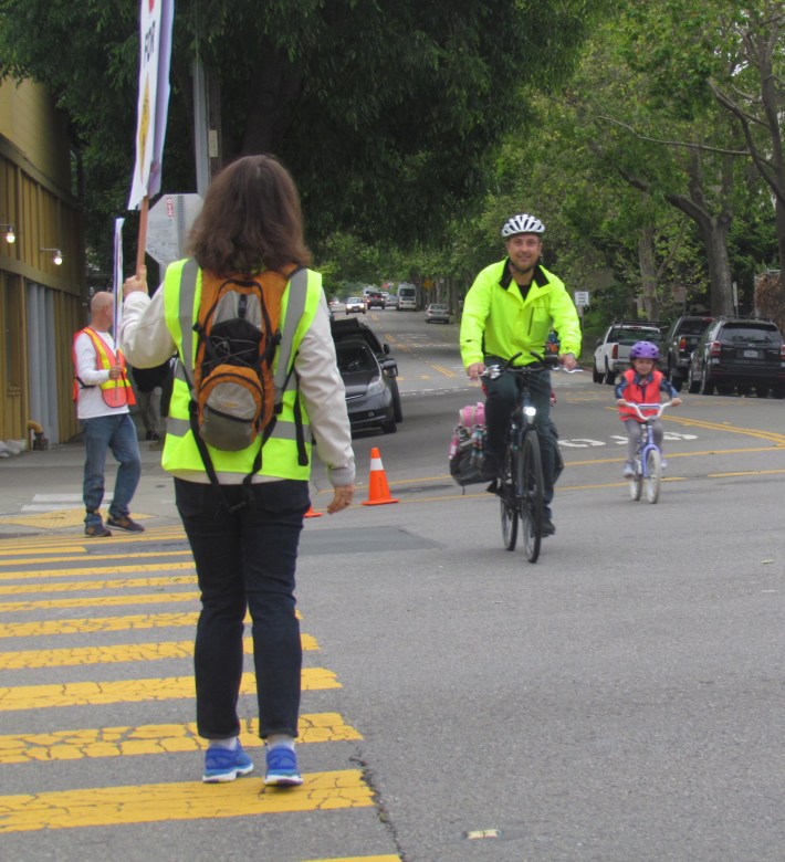 Volunteers stopped traffic so bike riders, including families, could cross safely.