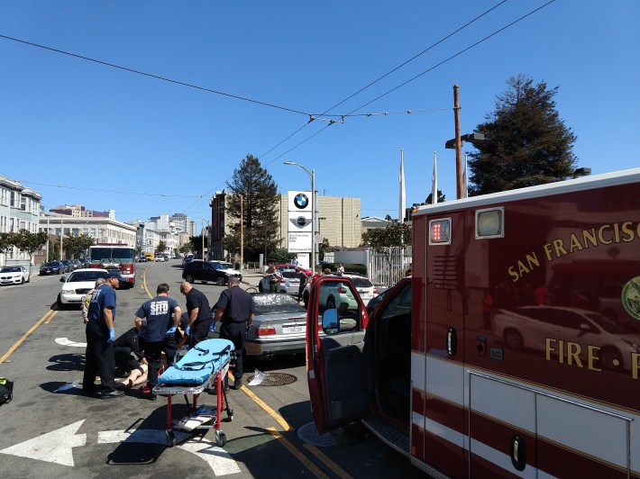 EMTs care for a man who was badly injured today while riding his bike at Howard and South Van Ness. Photo: Taylor Ahlgrem
