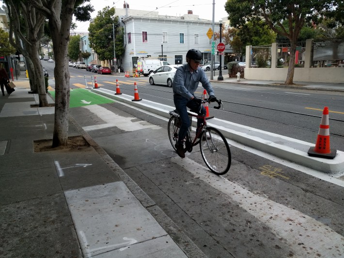 A cyclist enjoying the protected bike lane on 17th--no longer in fear of munching out on the tracks