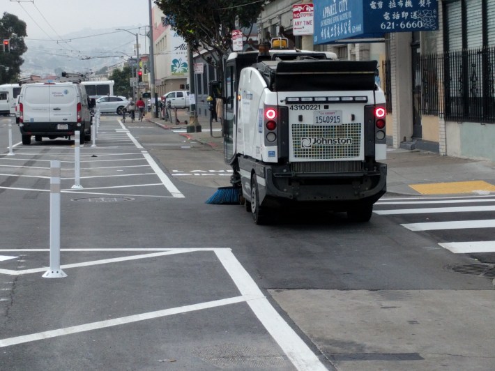 A min-street sweeper, cleaning an in-progress section of Howard's new protected bike lane
