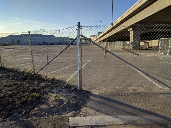 Fences force cyclists to circle around this big parking lot, instead of riding directly to 4th Street. They also make the path feel very unsafe, since riders are effectively trapped in a narrow space. Photo: Streetsblog/Rudick