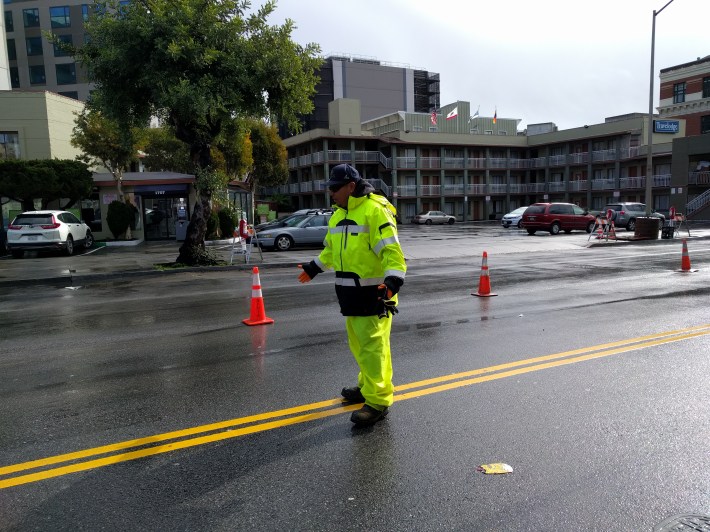 One of the SFMTA crew members showing how the yellow stripe will be moved over to make room for the protected bike lane