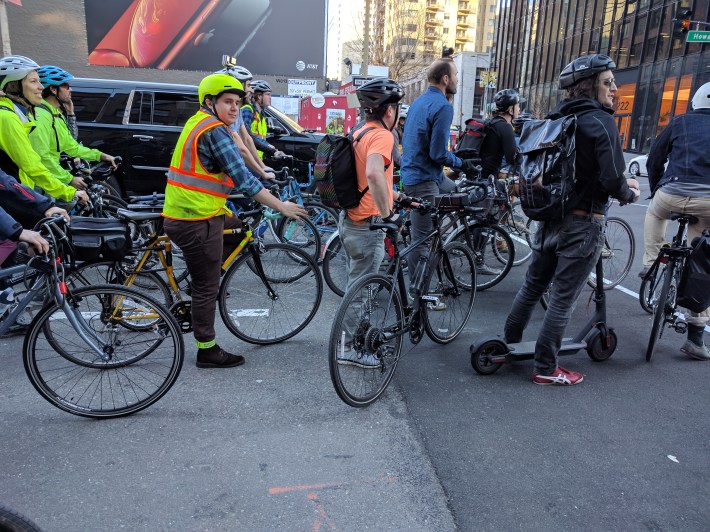 Cyclists waiting to ride across __STREET?