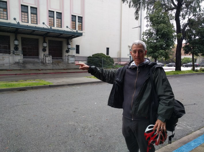 Grey Gardner standing next to the huge driveway his group hopes can be converted into more space for people (there's another driveway on the east side for cars).