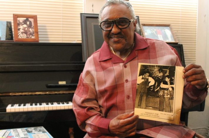 “Terrible” Tom Bowden with a photo of him singing with Aretha Franklin. Photo by Nathanael Johnson