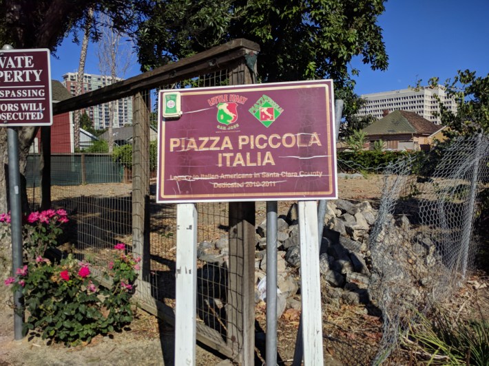 Little Italy as experience from the park. A nice welcoming sign, next to a threatening "no tresspassing" sign (partially out of frame to the left. And a fence.