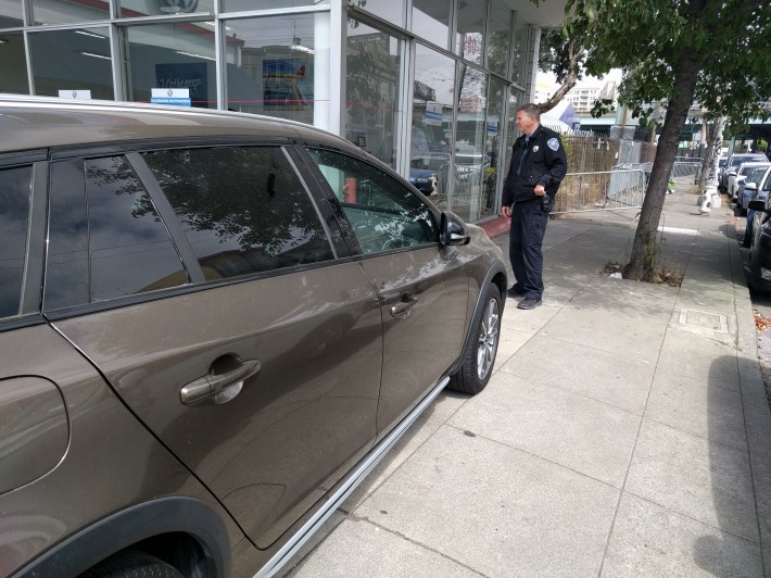 This SFMTA officer tickets Audi during the protest