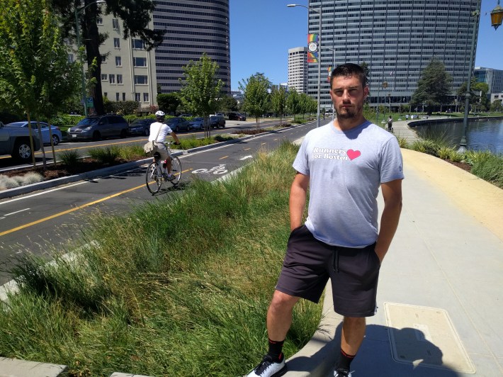 John Bauters after his interview today with Streetsblog. He wants protected infrastructure like the Lake Merritt cycletrack, behind him, installed everywhere in Emeryville. Photo: Streetsblog/Rudick