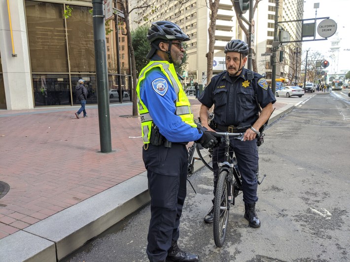 Commander Daniel Perea checking in with an SFMTA enforcement officer on the opening day of 'car-free' Market Street. Photo: Streetsblog/Rudick