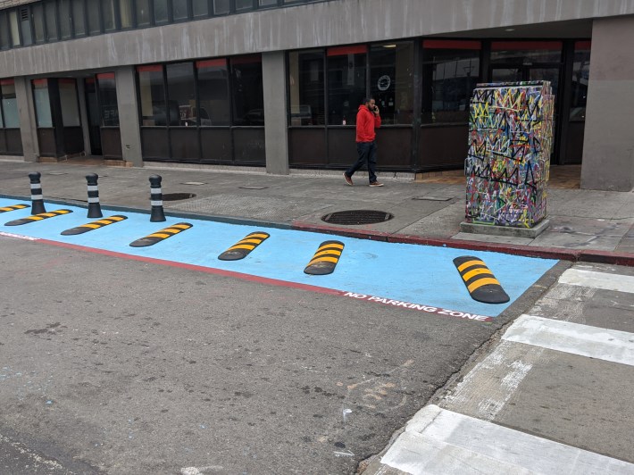 These strips force cars over if they attempt to enter the space from Broadway too quickly