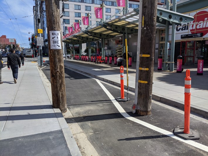 Concrete, asphalt and paint bend around utility poles to save money, since this will all have to be torn up in a few years