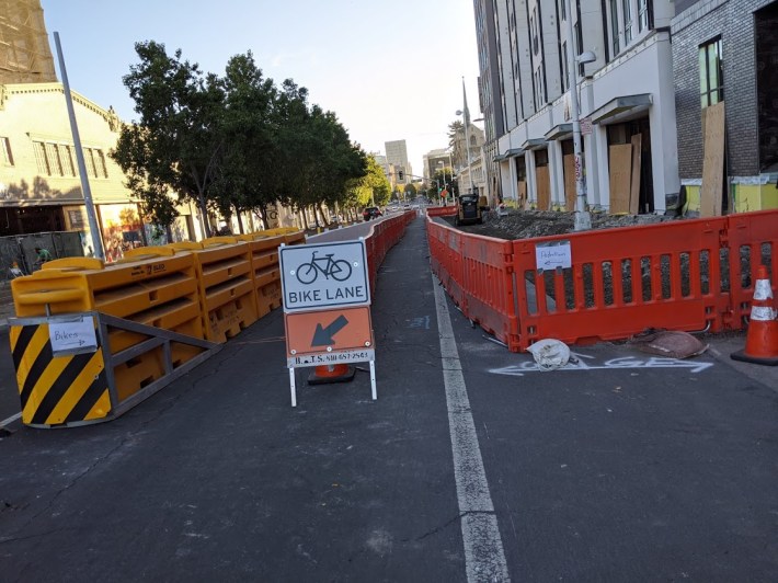 A temporary protected bike lane on Broadway, since removed. Why? And how can this be about money? Photo: Streetsblog/Rudick