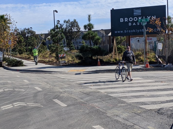 A cyclist, perhaps too intimidated by the heavy traffic and blocked bike lanes, walking his bike outside of Brookyn Basin