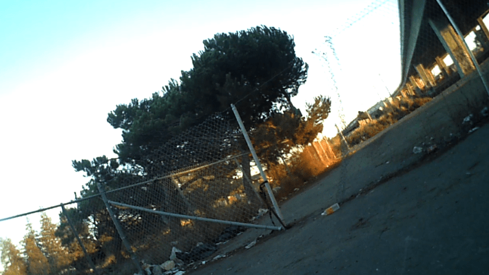 The cut through in the fence under the freeway. Still from a rear facing bike camera. Photo: Streetsblog/Rudick