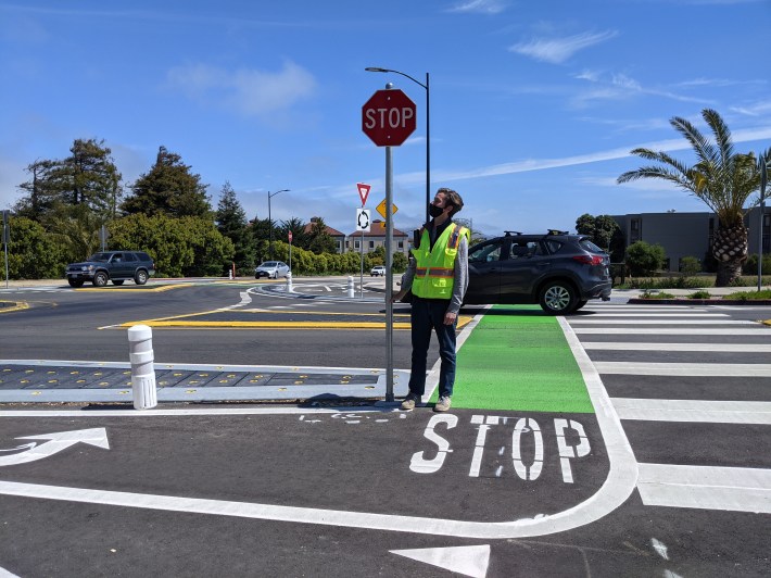 Starkey posing next to one of the stop signs that has given him so much grief from advocates