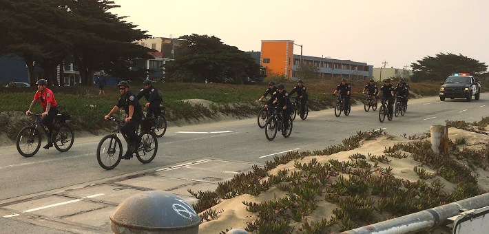 Two days after the Great Highway reopened to cars, wildfire smoke tinted the sky and SF police took an escorted bike ride along the beachfront road. (Photo: Alex Lash)