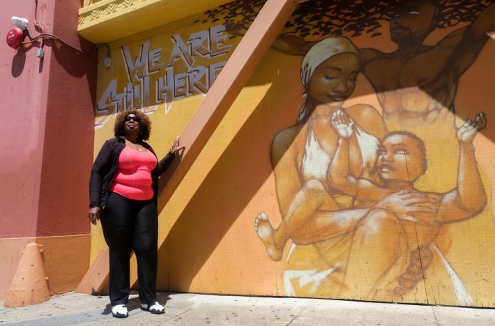 Phelicia Jones, founder of Wealth and Disparities in the Black Community and the Justice 4 Mario Woods Coalition, poses in front of the African American Art & Culture Complex. | Photo by Camille Cohen