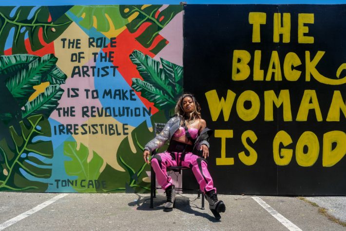 An event attendee poses in front of the open-air gallery located in the AAACC’s parking lot. | Photo by Camille Cohen