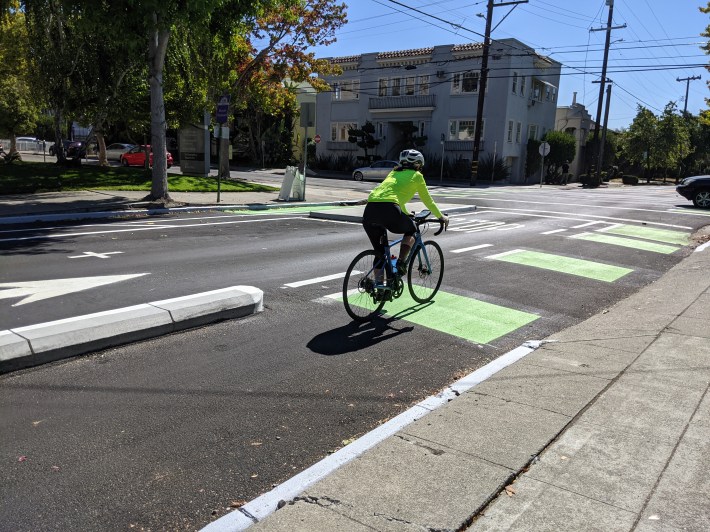 A cyclist heading down Milvia's now protected bike lane