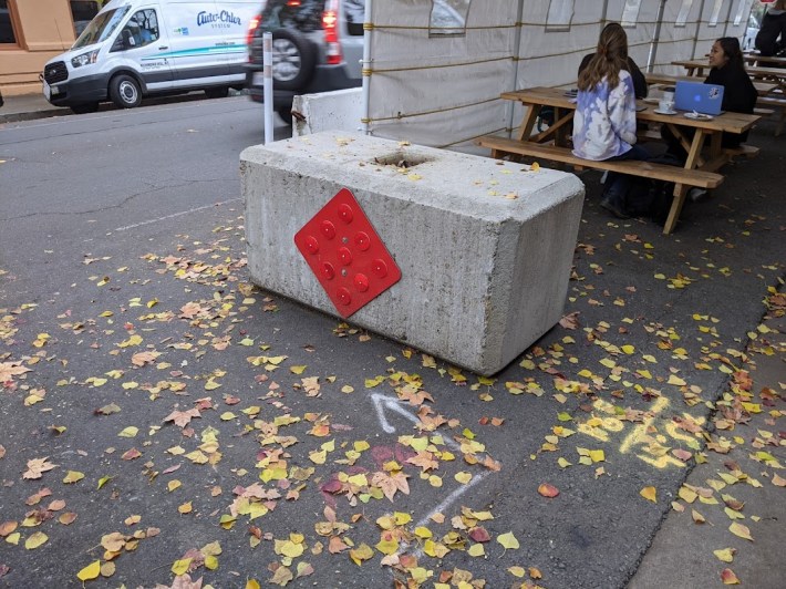 A parklet in Davis, CA, protected by a solid concrete block and concrete gravity rail. This is what cities use when they're serious about safety. Photo: Streetsblog/Rudick