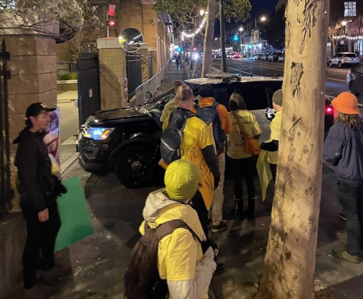 The cop who couldn't be bothered to pull into the parking lot, park, and walk back ten feet to talk with the demonstrators, instead blocking the sidewalk and the group. Photo: Austin Day