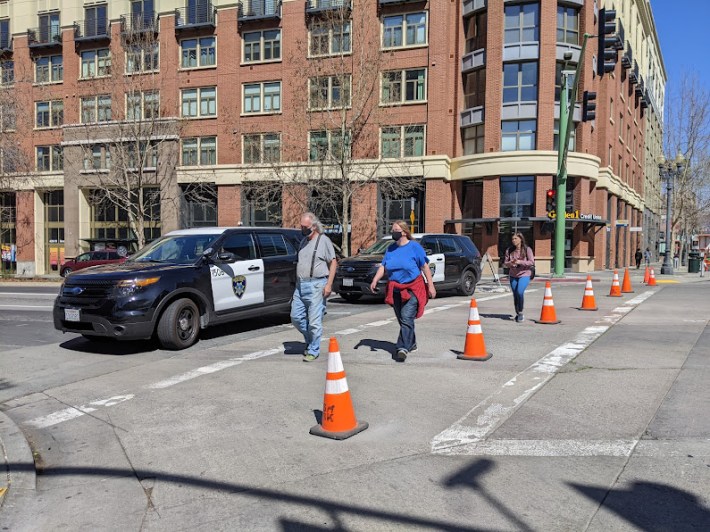 Pedestrians calmly crossing an intersection on Broadway.