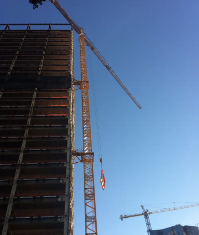 The crane that had to be jury rigged to the side of the building to strip off the skin