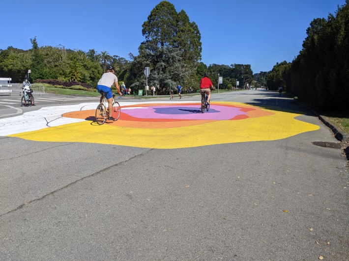 A street mural midway through installation. The white on the left is primer. Photo: Streetsblog/Rudick