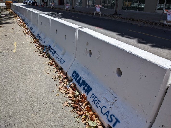 A construction site in Oakland. The sidewalk is closed, so concrete Jersey barrier were placed in the street to protect pedestrians. Cyclists need the same level of protection. Photo: Streetsblog/Rudick