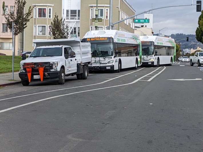 A city vehicle parked in the bus stop.