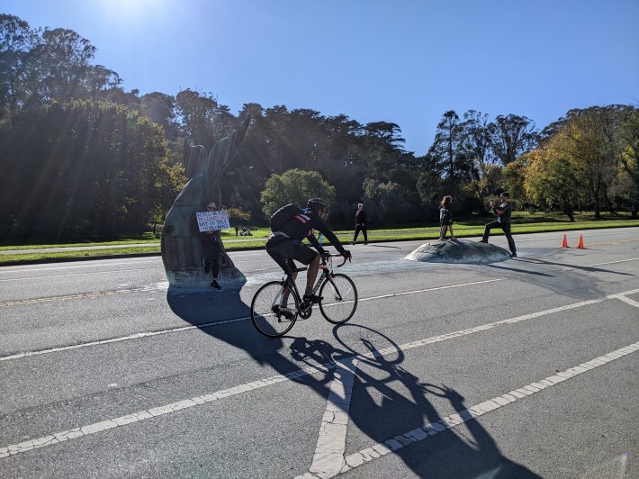 A cyclist riding past the Whale's Tail art on JFK, near where the festivities were held