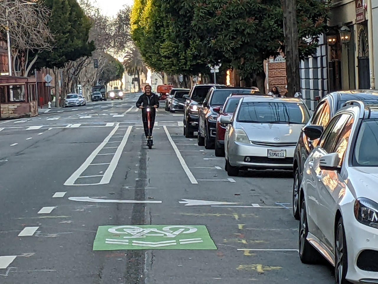 Farther down the street, a striped bike lane in the door zone on the wrong side