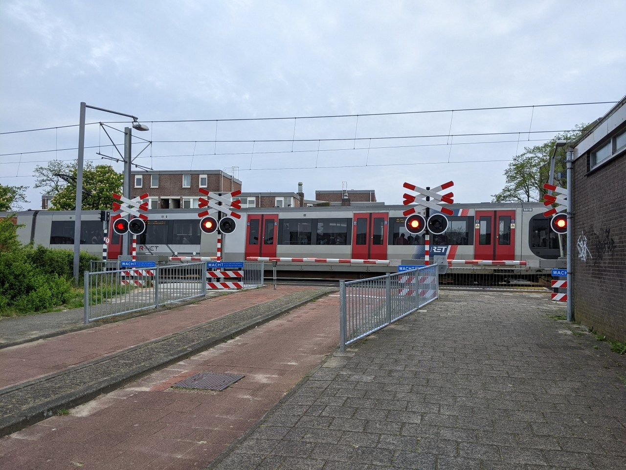 The Rotterdam metro running on the surface, at a bicycle grade-crossing
